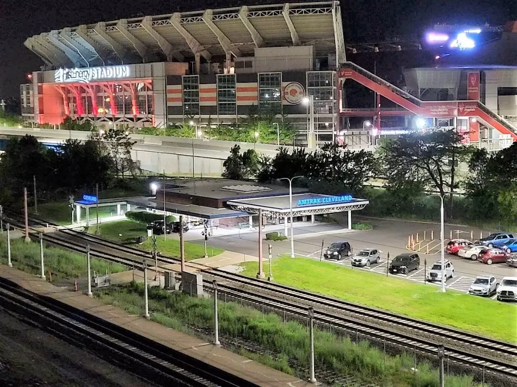 Cleveland's Amtrak station looks lonely in the middle of the night with Cleveland Browns stadium in the background.